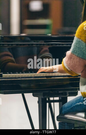 Rückansicht des Piano keys und Frau Hände während der Wiedergabe von Musik. Stockfoto