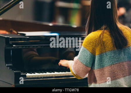 Kopf und Schultern der Frau spielt am Piano in Concert Hall. Stockfoto