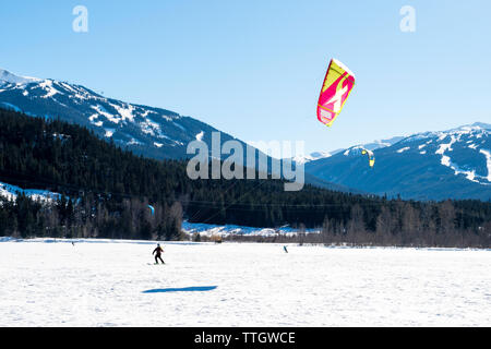 Ein Mann kite Ski auf einem zugefrorenen See an einem sonnigen Wintertag in Whistler Stockfoto