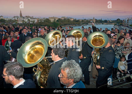 Heilige Woche. Bruderschaft des La O. Musik band Prozession auf der Brücke von Triana (im Hintergrund der Fluss Guadalquivir und der Stadt). Sevilla. Region Stockfoto