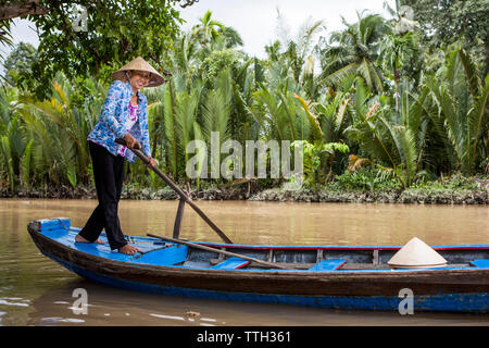 Eine Frau, die Paddel ein Boot im Mekong Delta, Vietnam. Stockfoto