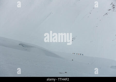 Gruppe von Alpinisten auf ihrem Weg durch die verschneite Landschaft Stockfoto