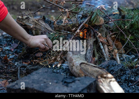 Frau beginnt ein Feuer in einem Kamin in der Wald im Herbst Stockfoto