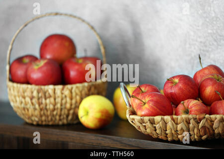 Wicker Fach mit reifen Äpfeln auf hölzernen Tisch Stockfoto