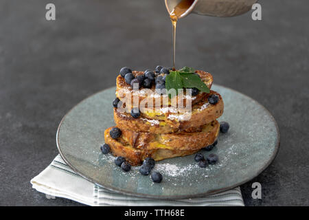 Stapel von French Toast mit Blaubeeren und Gießen Ahornsirup Stockfoto