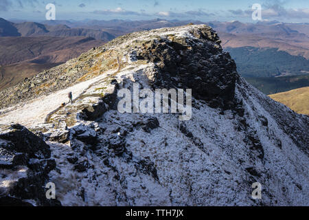 Frau und kleinen Hund entlang Pfad auf verschneiten Berg ridgeline Stockfoto
