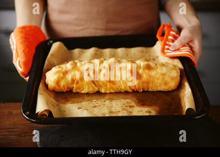 Frau mit Fach mit einer Raw apple Roll Stockfoto