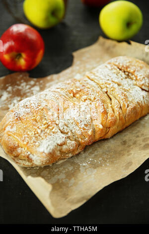 Strudel mit Äpfeln, Nüssen und Rosinen auf Pergament Stockfoto