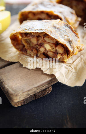 Scheiben von Strudel mit Äpfeln, Nüssen und Rosinen auf Pergament Stockfoto