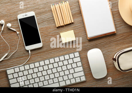 Arbeitsplatz mit Handy, Peripheriegeräte und Schreibwaren auf hölzernen Tisch Stockfoto