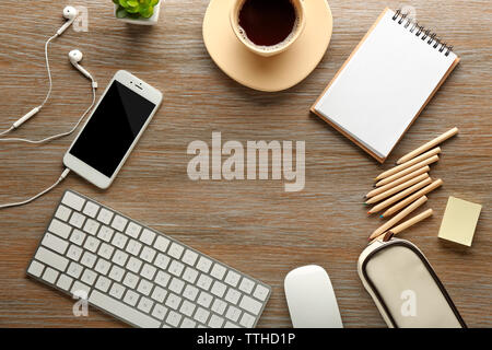 Arbeitsplatz mit Handy, Peripheriegeräte und Schreibwaren auf hölzernen Tisch Stockfoto