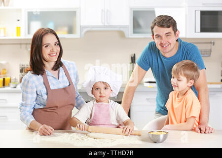 Junge Eltern sehen, wie ihr Sohn sich zu einem Teig rollen, in der Nähe Stockfoto