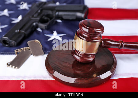 Hammer mit Gewehr und Marken auf dem Hintergrund der USA-Flagge Stockfoto