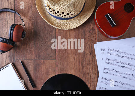 Gitarre, Kopfhörer, Musik, Blätter und Stroh Hut auf Holz- Oberfläche, Ansicht von oben Stockfoto