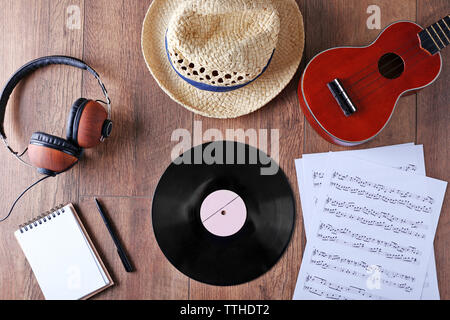 Gitarre, Kopfhörer, Musik, Blätter und Stroh Hut auf Holz- Oberfläche, Ansicht von oben Stockfoto
