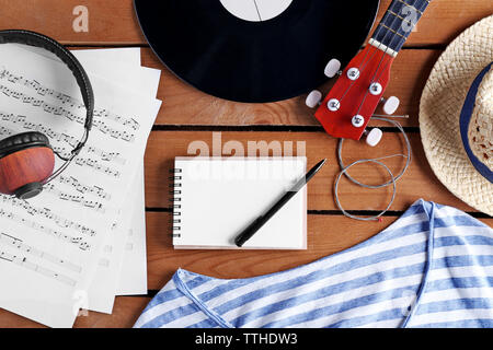 Gitarre, Kopfhörer und Musik Blätter auf Holz- Oberfläche, Ansicht von oben Stockfoto