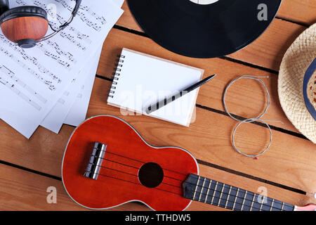 Gitarre, Kopfhörer und Musik Blätter auf Holz- Oberfläche, Ansicht von oben Stockfoto