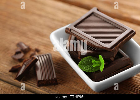 Schokolade mit Minze in einer weißen Schüssel auf Holztisch. Stockfoto