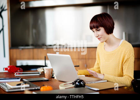 Konzentriert Geschäftsfrau mit Laptop auf dem Schreibtisch in der kreativen Büro Stockfoto