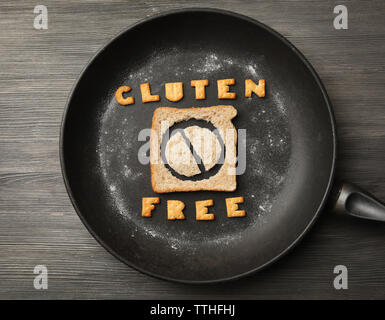 Das Brot in Scheiben schneiden, in einer Pfanne mit Glutenfreien text auf Holz- Hintergrund Stockfoto
