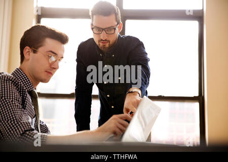Geschäftsleute diskutieren im Büro über Laptop Stockfoto