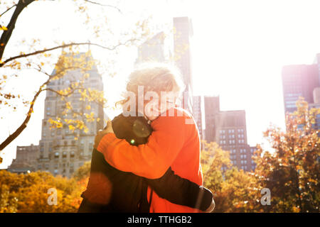 Glückliches junges Paar umarmen im Central Park an einem sonnigen Tag Stockfoto