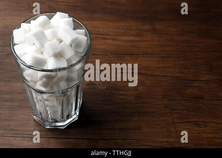 Highball Glas mit Klumpen Zucker auf hölzernen Tisch Stockfoto