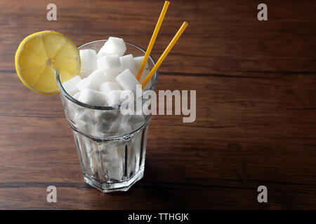 Highball Glas mit Klumpen Zucker auf hölzernen Tisch Stockfoto