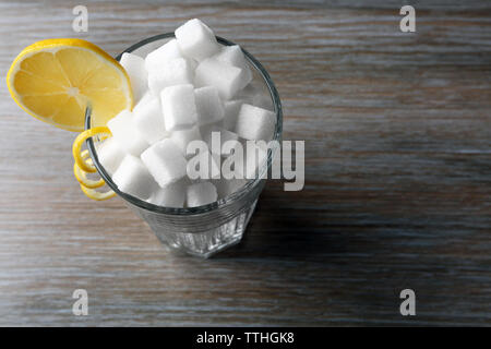 Highball Glas mit Klumpen Zucker auf hölzernen Tisch Stockfoto