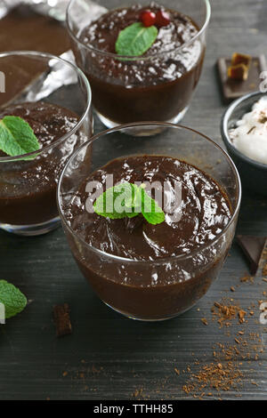 Glas Tassen Schokolade Dessert mit frischer Minze auf schwarzen Holztisch Stockfoto