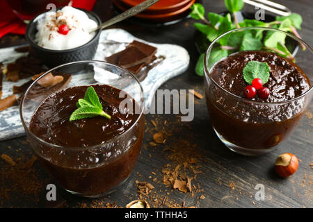 Glas Tassen Schokolade Dessert mit frischer Minze auf schwarzen Holztisch Stockfoto