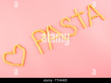 Pasta Wort mit Fusilli auf rosa Hintergrund gemacht Stockfoto