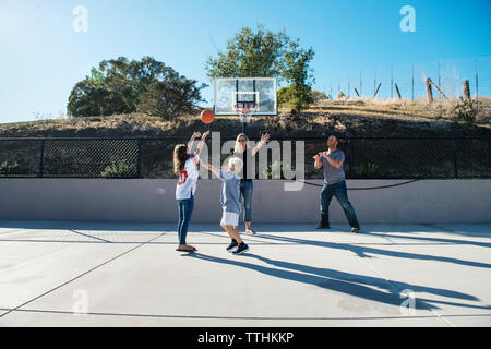 Familie Basketball spielen an einem sonnigen Tag Stockfoto