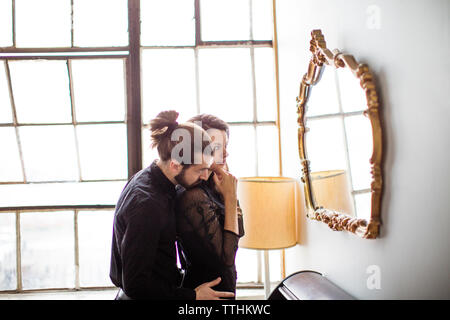 Seitenansicht des Paar umarmen und Spiegel Stockfoto