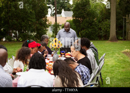 Familie und Freunde in Essen am Tisch im Hinterhof Stockfoto