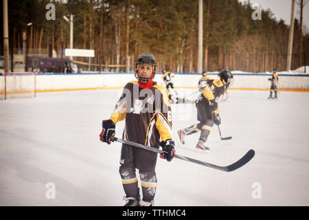 Portrait von Spieler mit Ice Hockey Stick beim Stehen auf Rink Stockfoto