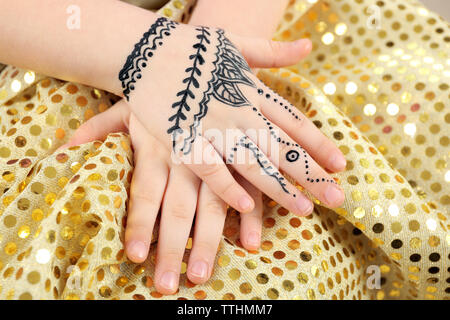 Henna Ornamente auf Girl's Hand auf Farbe Hintergrund Tuch Stockfoto