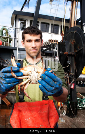 Portrait von Fischer holding Krabben und stehen auf dem Boot Stockfoto