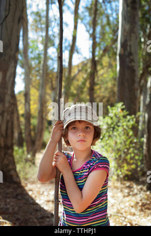 Portrait von Mädchen, dass Stick beim Stehen in Wald Stockfoto