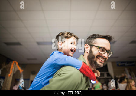 Freundliche Vater piggyback Sohn Stockfoto