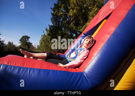 Mädchen entspannen auf hüpfburg im Vergnügungspark Stockfoto