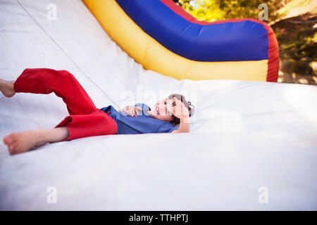 Glückliche junge spielt auf der Hüpfburg im Vergnügungspark Stockfoto