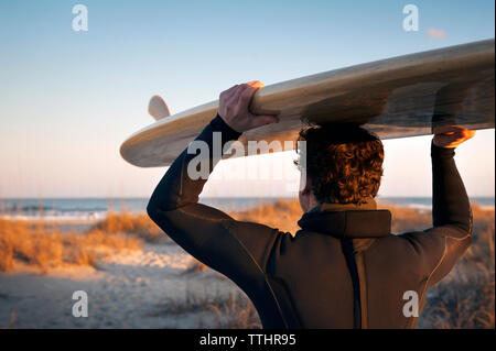Nahaufnahme der Surfer, Surfbrett auf dem Kopf am Strand Stockfoto