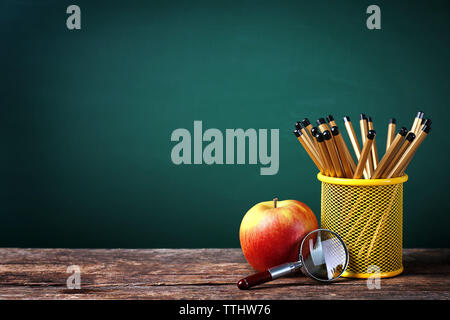 Set Bleistifte in Metall, Lupe und Apple auf blackboard Hintergrund Stockfoto