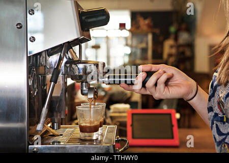 7/8 Bild der Frau mit Kaffeemaschine im Cafe Stockfoto