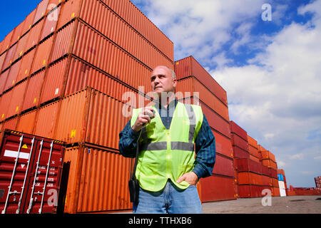 Low Angle View des Arbeitnehmers gegen Cargo Container Stockfoto