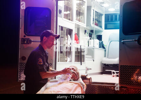 Die Sanitäter, die Behandlung von Patienten im Krankenhaus gurney in der Nacht Stockfoto