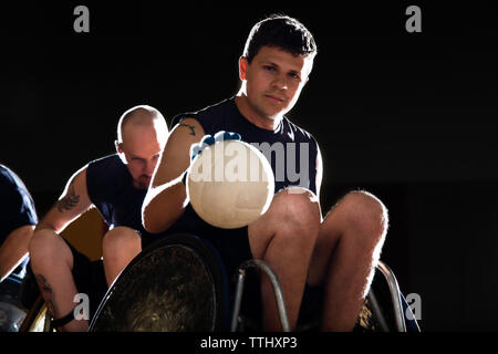 Porträt des Menschen dribbeln Ball während des Spielens Rollstuhl Rugby in Hof Stockfoto