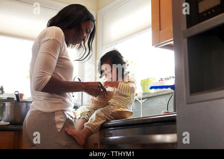 Mutter und Tochter an der Schüssel in der Küche auf der Suche Stockfoto