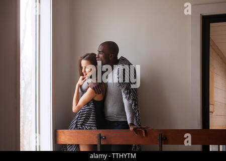 Paar weg schauen, während Sie von Geländer zu Hause stehend Stockfoto